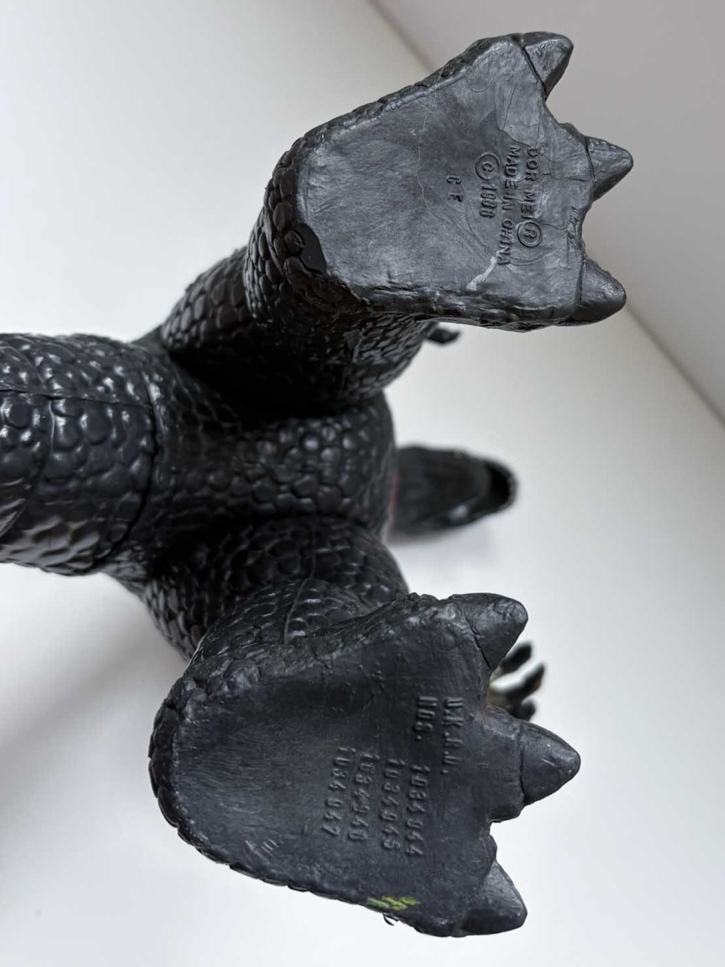 The undersides of both feet of a Dor Mei vinyl kaiju. The left foot is moulded DOR MEI, registered trademark, MADE IN CHINA, copyright 1986. The right foot carries a list of United States patent numbers.
