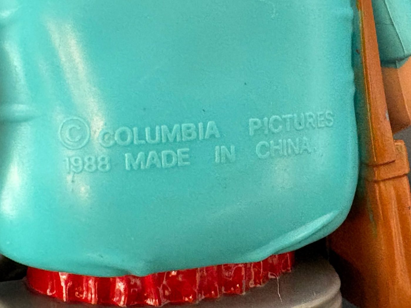 The moulded stamp across the back of a Kenner Haunted Humans Mail Fraud figure's turquoise shirt, reading copyright Columbia Pictures 1988, Made in China