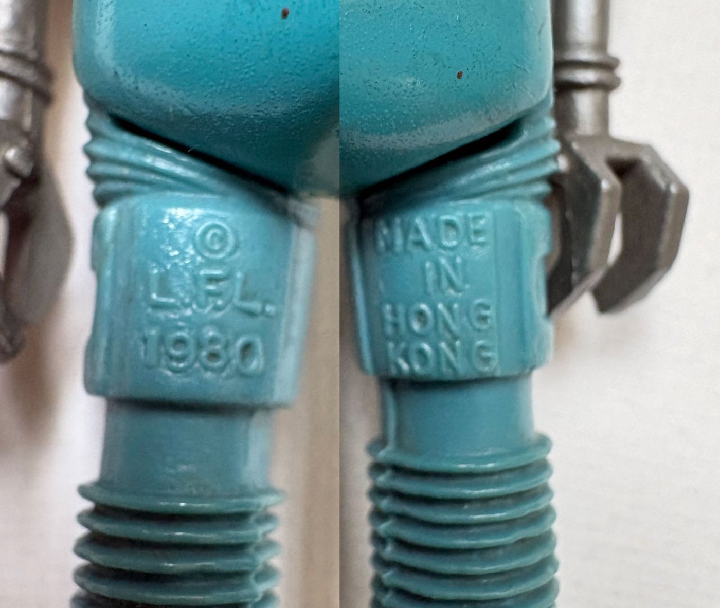 Macro photograph of the inner thighs of a blue Kenner 2-1B figure, the left leg moulded with the words copyright L.F.L. 1980 and the right leg moulded MADE IN HONG KONG