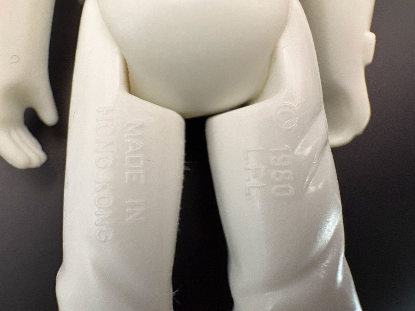 Macro photograph of the inner thighs of a white Kenner Hoth Stormtrooper figure, the left leg moulded MADE IN HONG KONG and the right leg moulded copyright 1980 L.F.L.