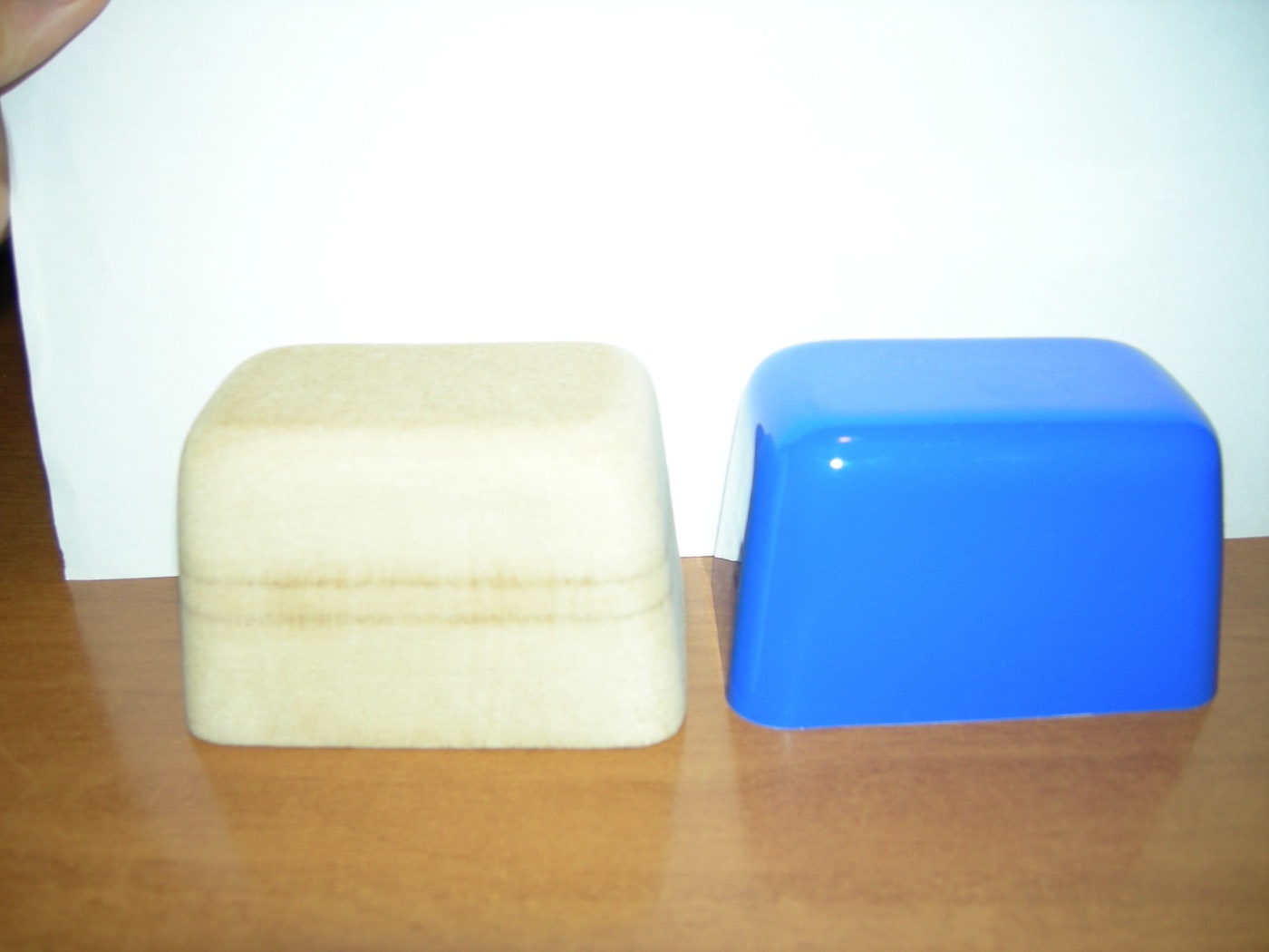 A wooden former beside the blue plastic shell that was vacuum formed over it