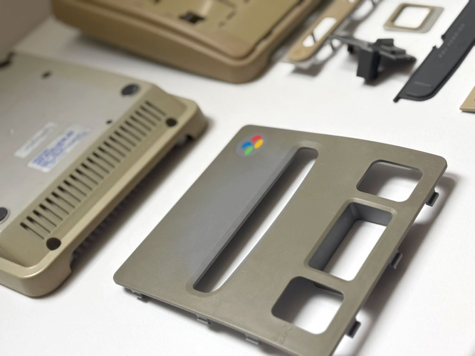 Close-up of the yellowed top panel with the four-colour Super Nintendo logo, the olive cast running right across the moulding.